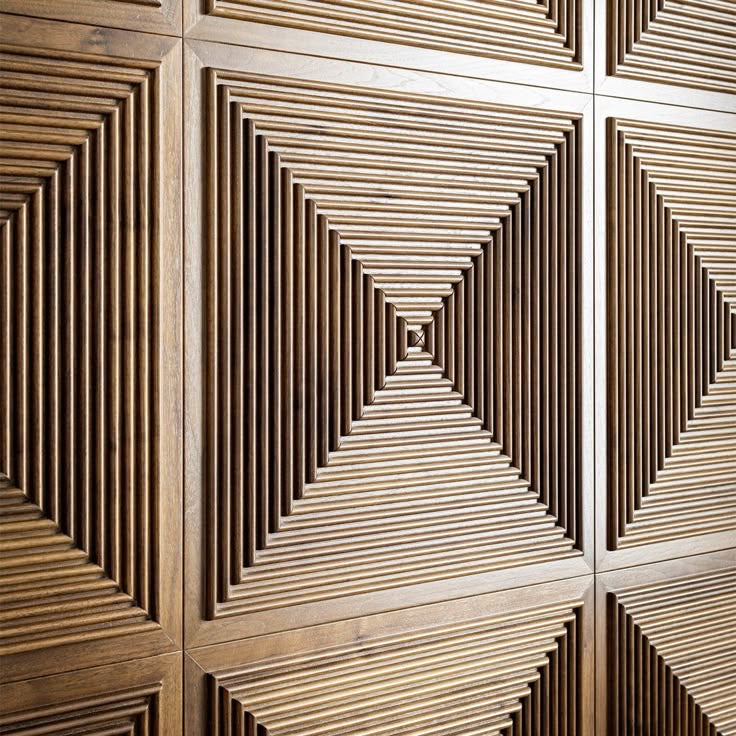 Close-up of 24x24 inch carved acoustic wall panels in maple, showing precise linear relief and shadow depth.
