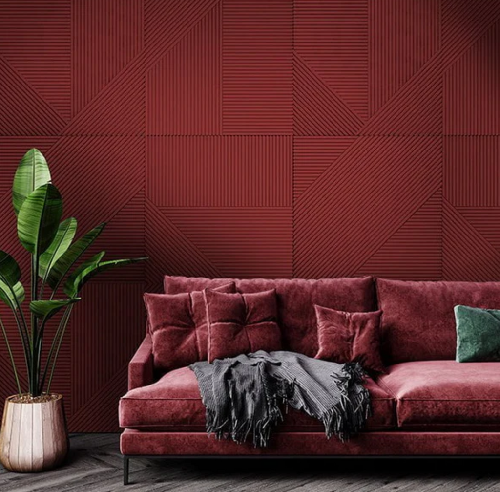 Deep maroon NoirBloc accent wall tiles in a living room setting with a matching velvet couch and cozy lighting.