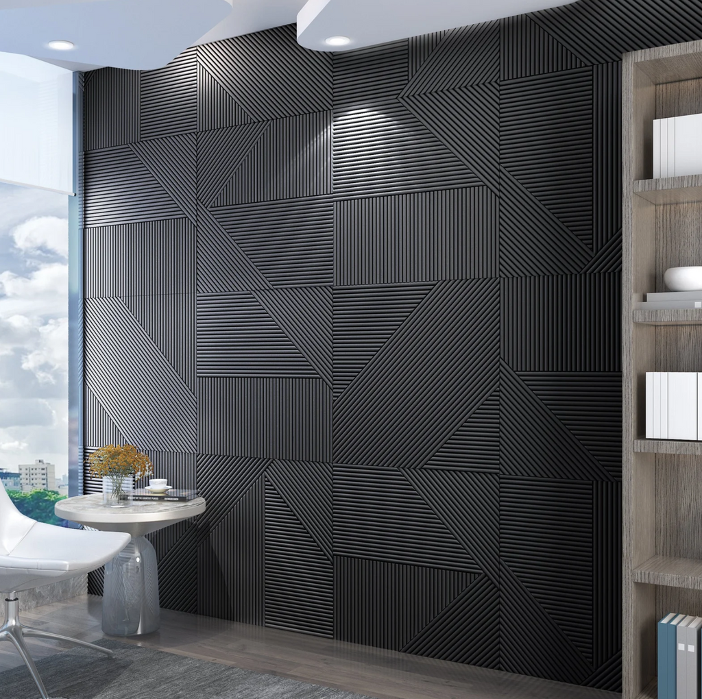 NoirBloc 24x24 inch geometric wall tile in matte black finish, shown behind a modern bed with directional spotlighting.